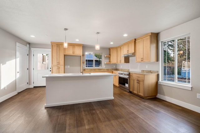 kitchen featuring dark wood-type flooring, high end stainless steel range, light countertops, light brown cabinetry, and under cabinet range hood