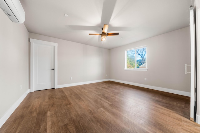 unfurnished bedroom with ceiling fan, baseboards, an AC wall unit, and wood finished floors