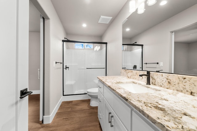 bathroom featuring toilet, wood finished floors, a shower stall, and visible vents