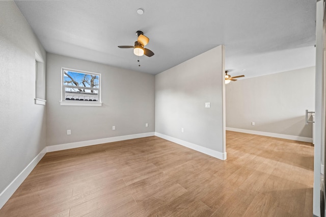 unfurnished room featuring light wood-style flooring, baseboards, and a ceiling fan