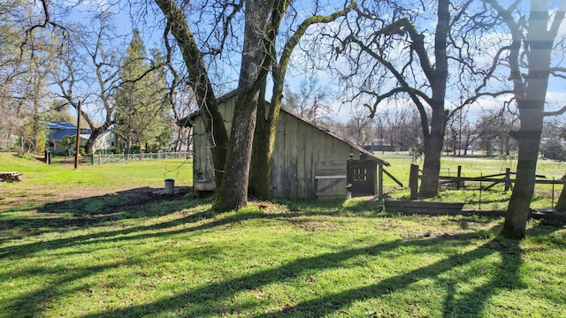 view of yard with a barn, an outdoor structure, and fence