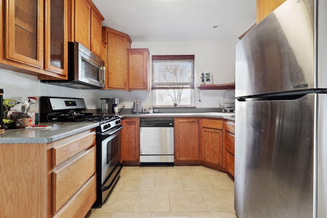 kitchen with open shelves, stainless steel appliances, glass insert cabinets, and brown cabinetry