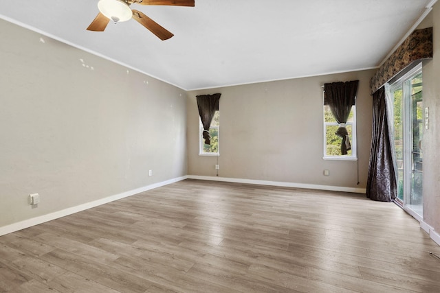 spare room with baseboards, ceiling fan, and light wood finished floors