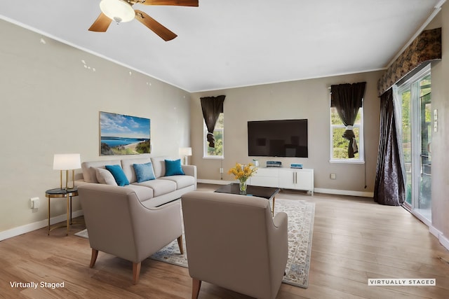 living area featuring ceiling fan, baseboards, and wood finished floors