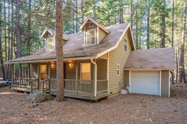 view of front of home with an attached garage, dirt driveway, and a porch