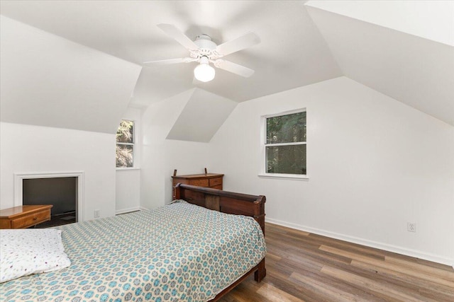 bedroom featuring ceiling fan, baseboards, vaulted ceiling, and wood finished floors