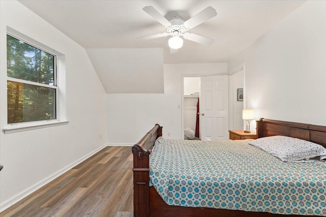 bedroom featuring a ceiling fan, vaulted ceiling, baseboards, and wood finished floors