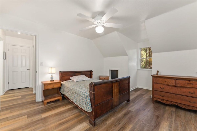 bedroom with lofted ceiling, baseboards, and wood finished floors