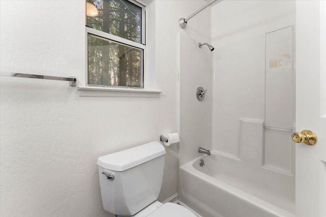 full bathroom with shower / bath combination, a textured wall, and toilet