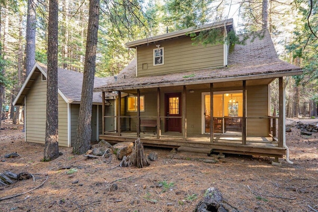 view of front of house with covered porch and a shingled roof