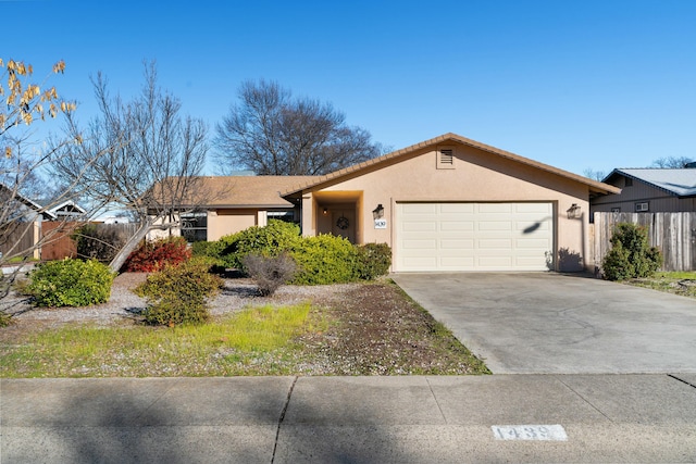 ranch-style house featuring a garage, driveway, fence, and stucco siding