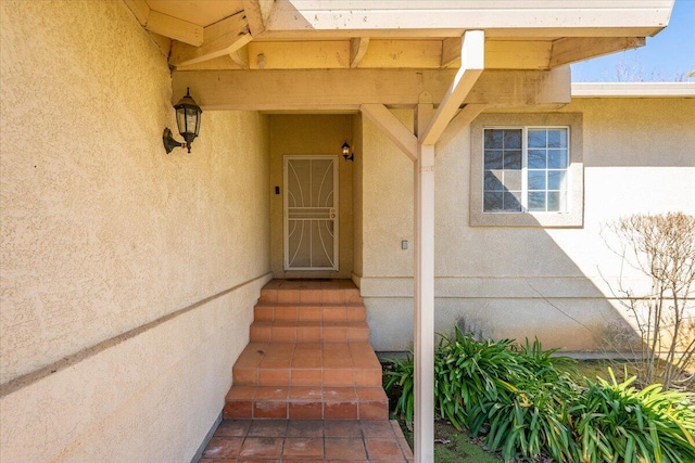 doorway to property featuring stucco siding