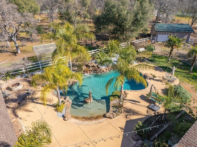 view of swimming pool featuring fence, an exterior structure, and an outdoor structure