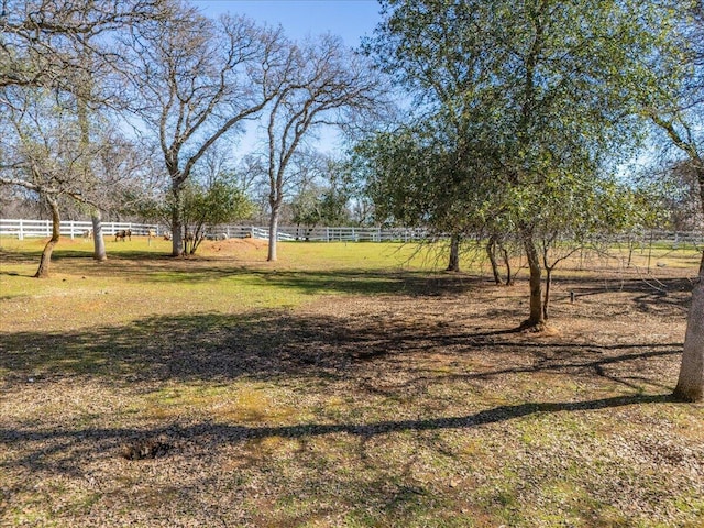 view of yard with a rural view and fence