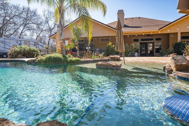 outdoor pool featuring a patio area, ceiling fan, and french doors