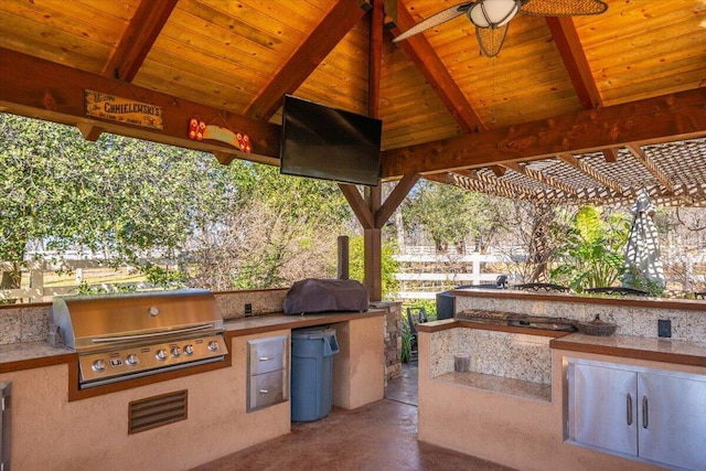 view of patio / terrace with ceiling fan, an outdoor kitchen, and a grill