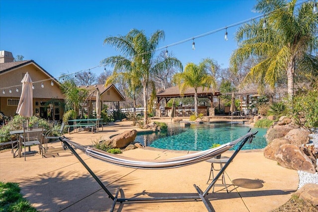 pool with a patio and a gazebo