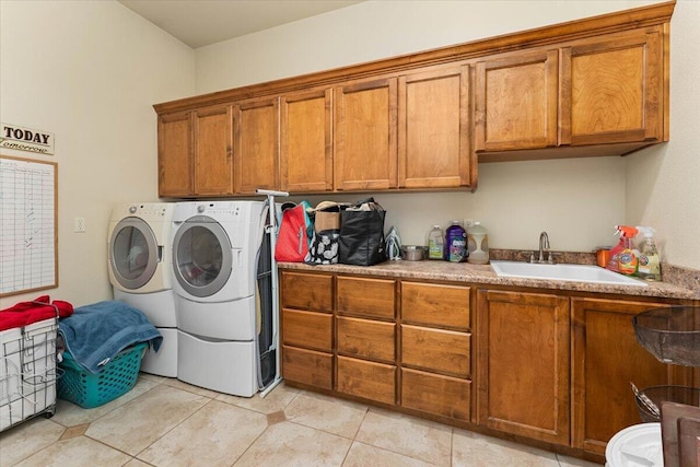 laundry area with washer and dryer, cabinet space, a sink, and light tile patterned floors