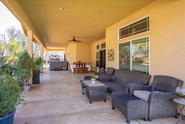 view of patio / terrace with ceiling fan, an outdoor hangout area, and a hot tub