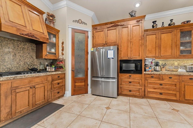 kitchen with light tile patterned floors, decorative backsplash, appliances with stainless steel finishes, brown cabinetry, and ornamental molding