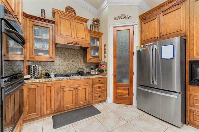 kitchen featuring crown molding, black appliances, backsplash, and brown cabinets