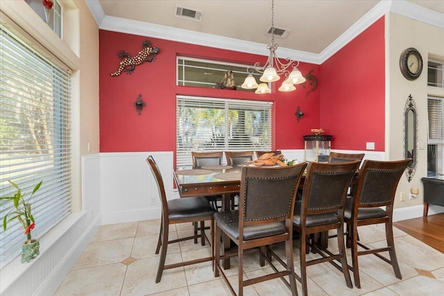 dining area with ornamental molding, wainscoting, and visible vents