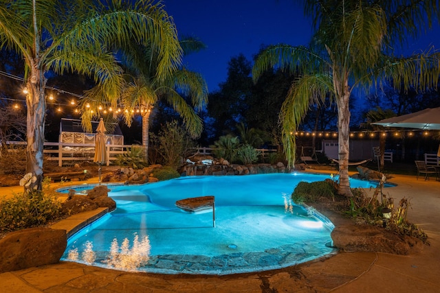 pool at twilight with an outdoor pool, a patio, and a jacuzzi