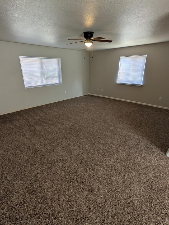 carpeted empty room with ceiling fan and a textured ceiling