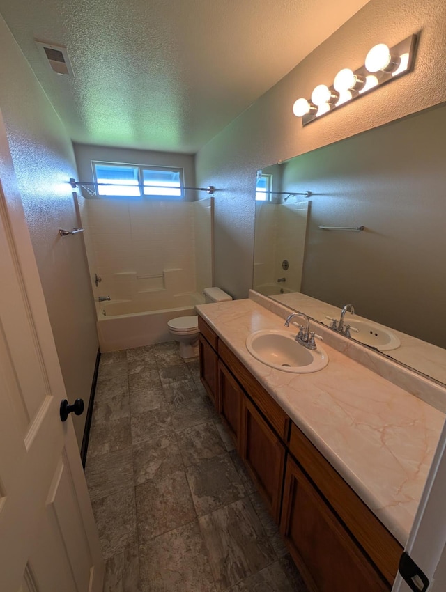 full bath featuring visible vents, bathing tub / shower combination, toilet, a textured ceiling, and vanity