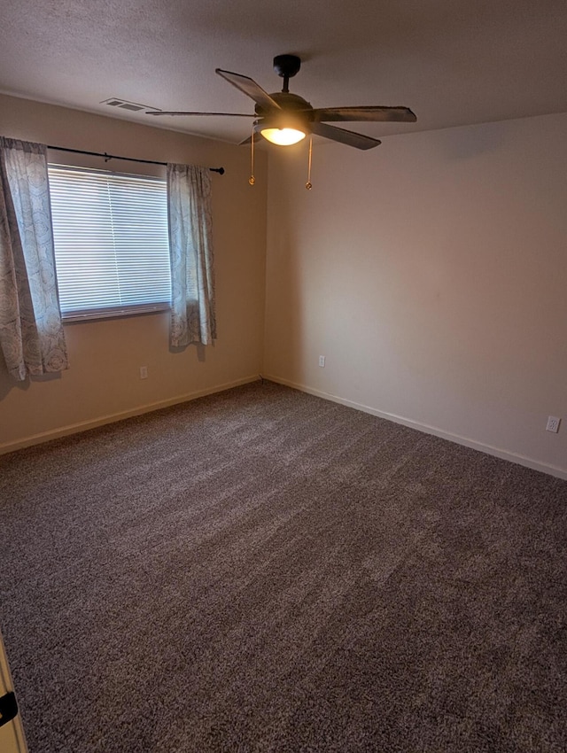 carpeted empty room with visible vents, ceiling fan, a textured ceiling, and baseboards