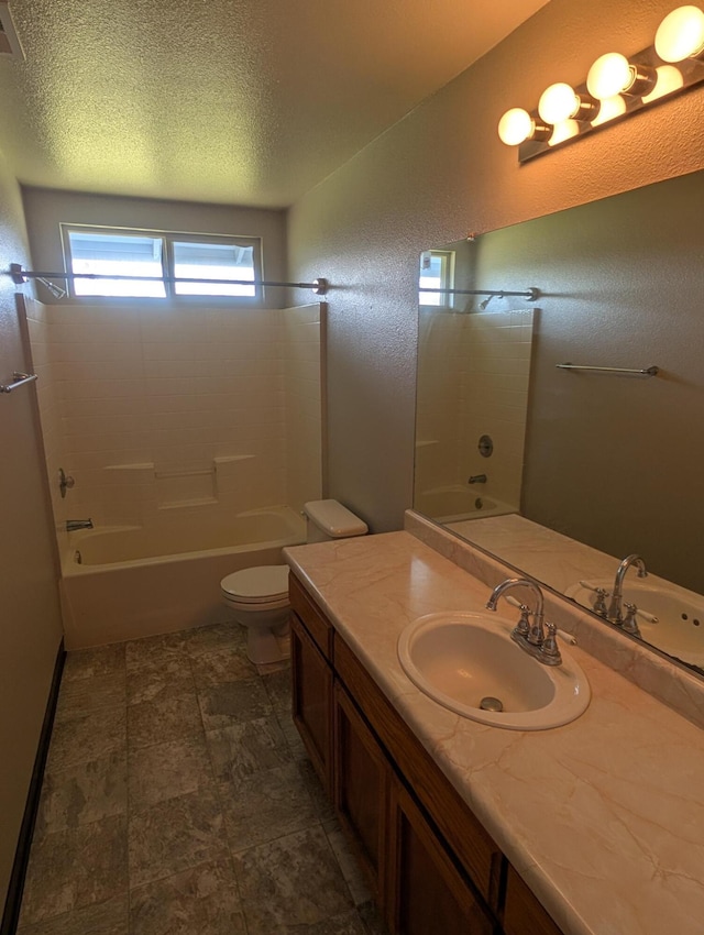 bathroom featuring bathtub / shower combination, a textured wall, toilet, vanity, and a textured ceiling