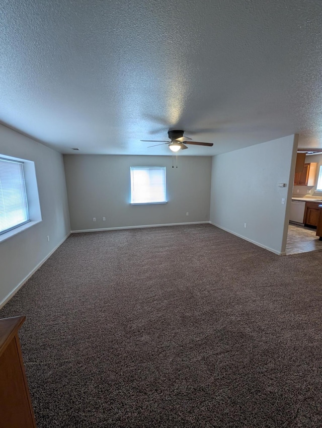 spare room featuring a ceiling fan, light colored carpet, a textured ceiling, and baseboards