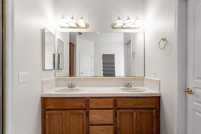 bathroom featuring double vanity, a sink, a closet, and visible vents