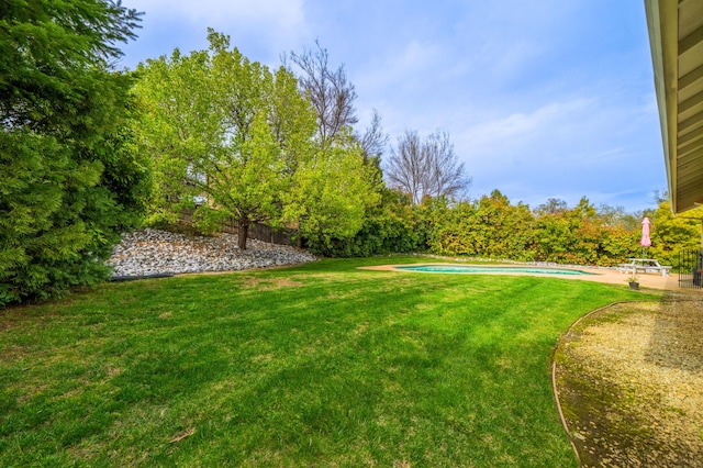 view of yard featuring an outdoor pool, fence, and a patio area