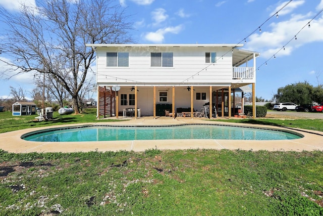 rear view of property with a ceiling fan, a yard, stairway, an outdoor pool, and a patio area