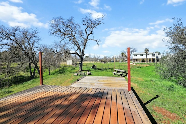 wooden terrace with a storage shed, a lawn, and an outdoor structure