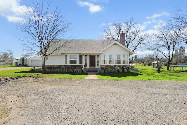 view of front of property with roof with shingles, a chimney, a front lawn, and stucco siding