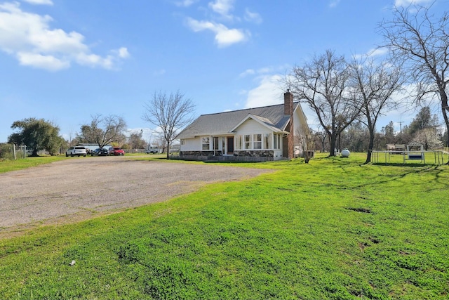 view of front of home with a front yard, driveway, and a chimney