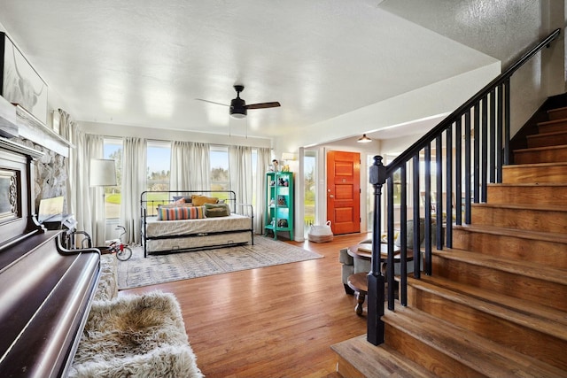 foyer with wood finished floors, ceiling fan, and stairs