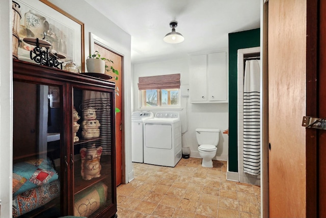 bathroom featuring stone finish flooring, independent washer and dryer, and toilet