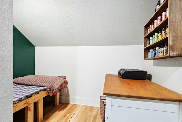 interior space with light wood-type flooring, white cabinetry, open shelves, and lofted ceiling