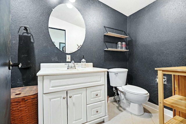 half bath with baseboards, a textured wall, toilet, tile patterned floors, and vanity