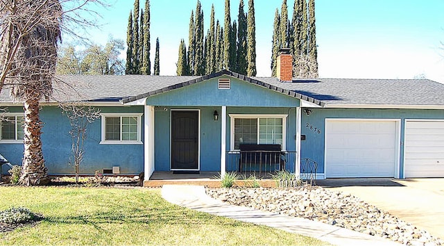 view of front of home with a garage, driveway, a chimney, covered porch, and a front lawn