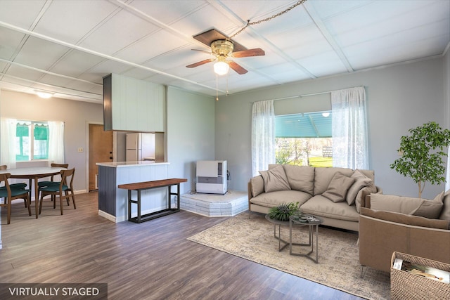 living area with baseboards, ceiling fan, and wood finished floors