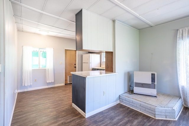 kitchen featuring heating unit, dark wood-style flooring, and freestanding refrigerator