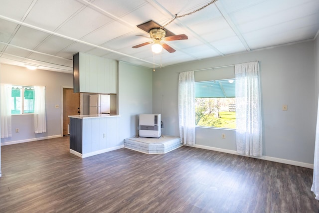 unfurnished living room featuring dark wood-style floors, plenty of natural light, ceiling fan, and baseboards