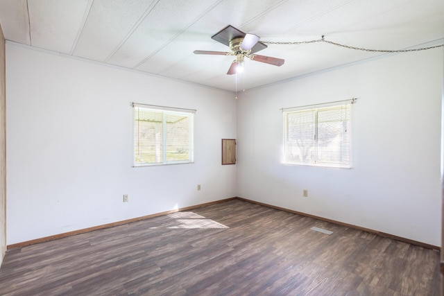 empty room with a wealth of natural light, baseboards, wood finished floors, and a ceiling fan