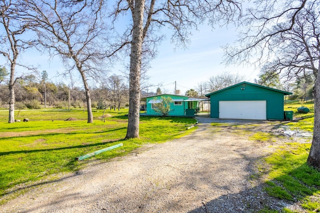 view of front of property with a front yard, an outbuilding, a garage, and driveway