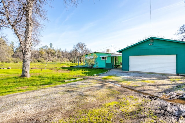 view of front of house with a garage, driveway, an outdoor structure, and a front lawn