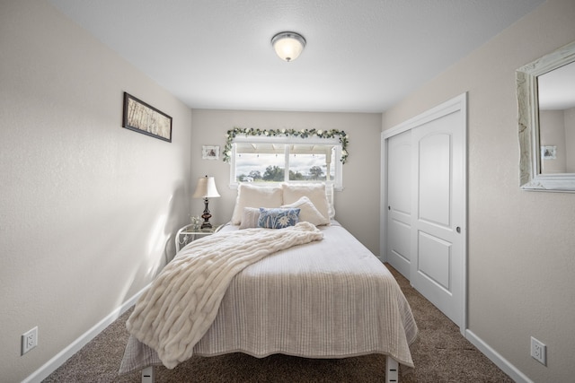 carpeted bedroom with a closet and baseboards